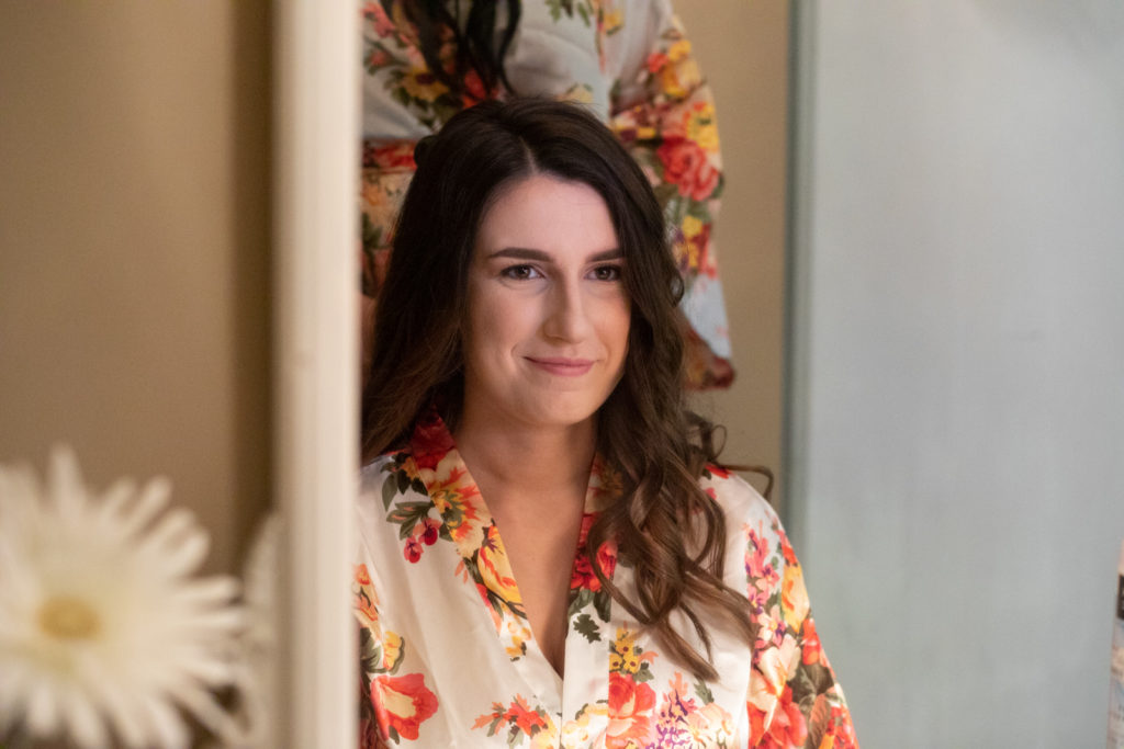 bride getting ready and smiling in mirror
